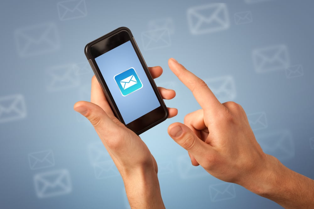 Female fingers touching smartphone with mail icon on it